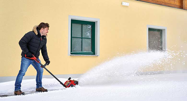 a man uses a snow blower