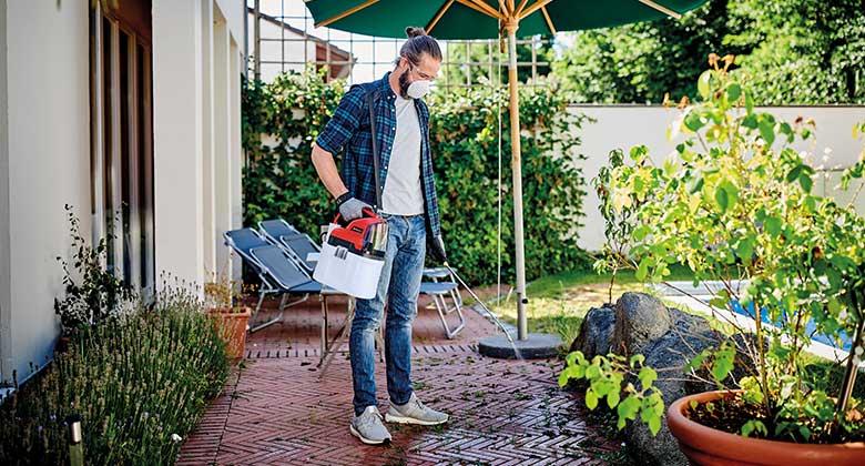 a man uses a pressure sprayer for his terraces flow